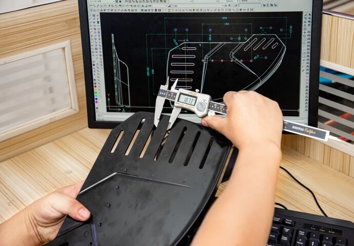 Measuring a mold in front of a computer