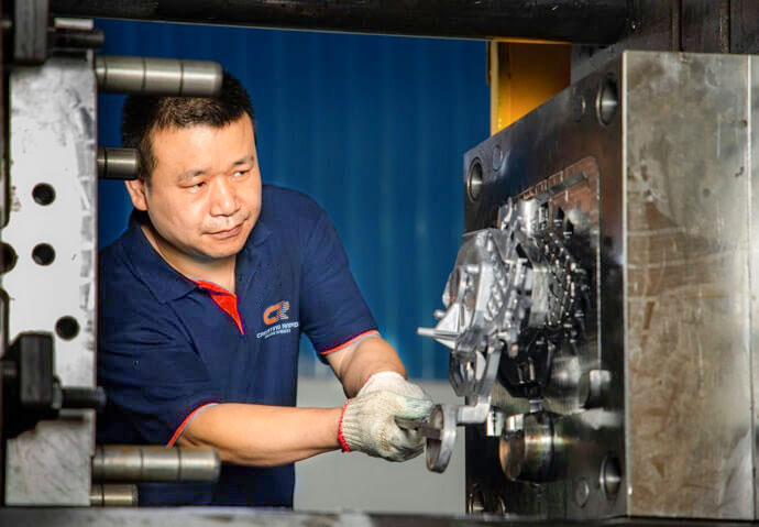 A worker adjusting the mold for tight tolerance