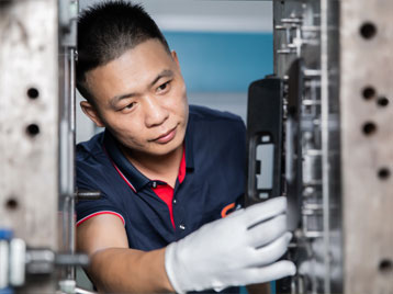 A worker testing the mold on an injection machine