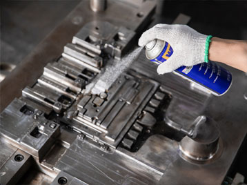 A worker spraying anti rust oil to the mold